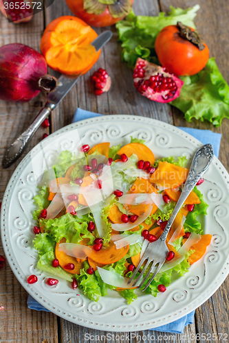 Image of Vitamin salad with persimmon, cheese and pomegranate seeds.