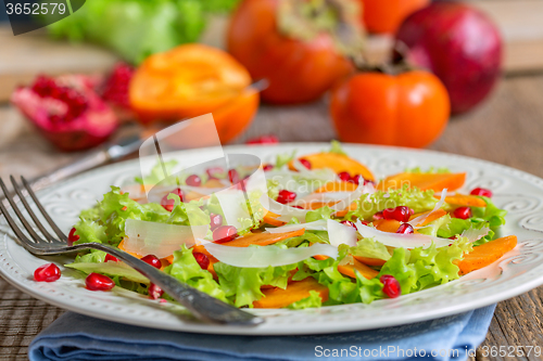 Image of Delicious salad with persimmon. Healthy food.