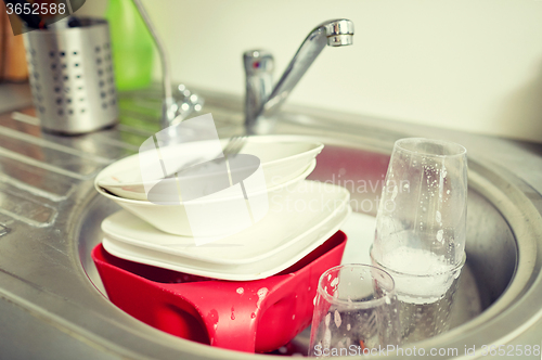 Image of close up of dirty dishes washing in kitchen sink