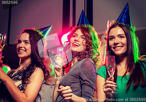 Image of smiling friends with glasses of champagne in club