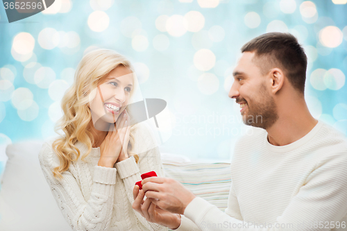 Image of happy man giving engagement ring to woman