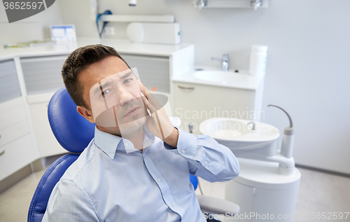Image of man having toothache and sitting on dental chair