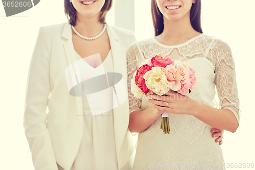 Image of close up of happy lesbian couple with flowers