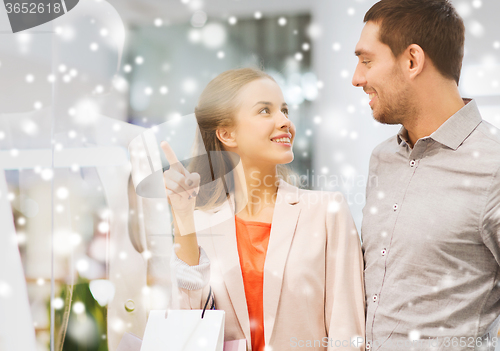 Image of happy young couple with shopping bags in mall