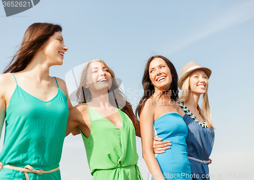 Image of smiling girls walking on the beach