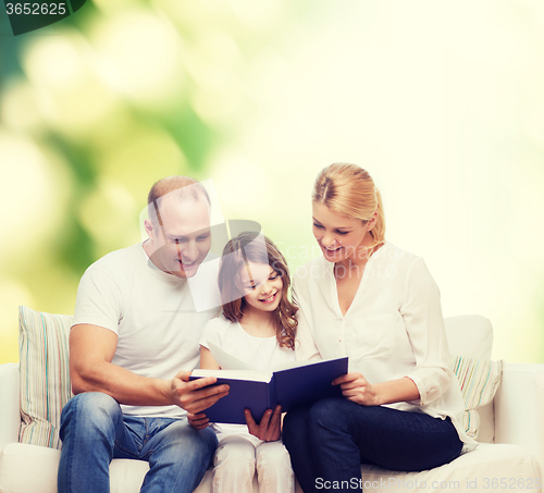 Image of happy family with book at home