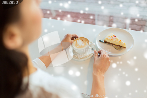 Image of close up of woman hands with cake and coffee