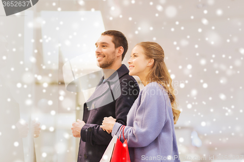 Image of happy young couple with shopping bags in mall