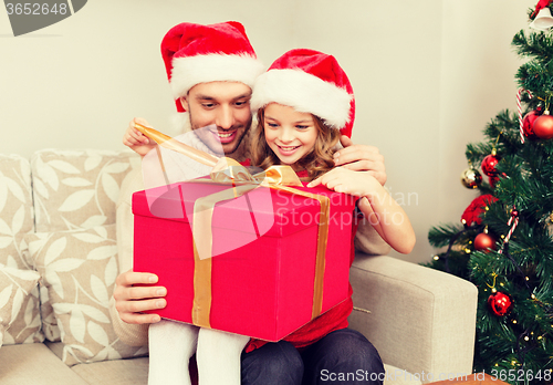 Image of smiling father and daughter opening gift box