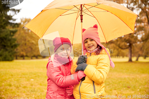 Image of happy little girls with umbrella in autumn park