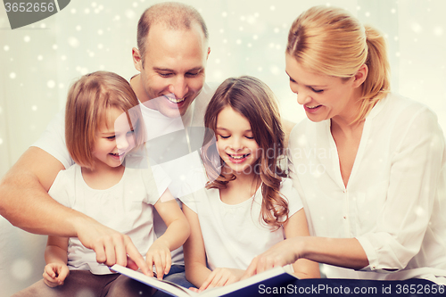 Image of happy family with book at home