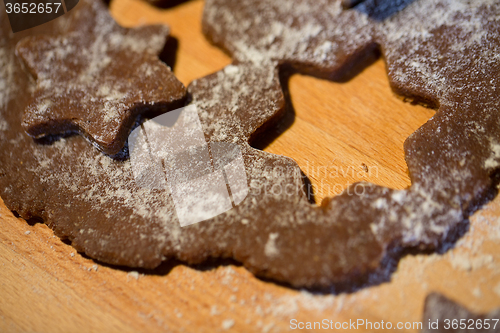 Image of close up of ginger dough, molds and flour on board