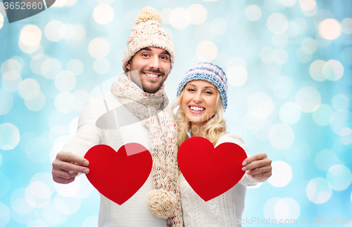 Image of smiling couple in winter clothes with red hearts