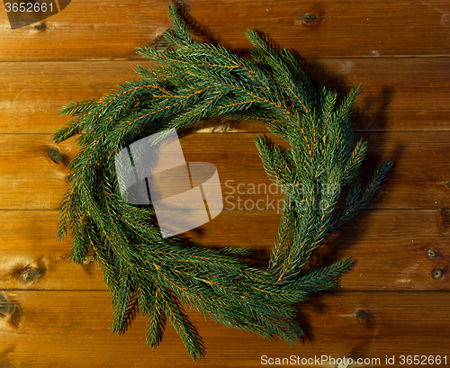 Image of natural green fir branch wreath on wooden board