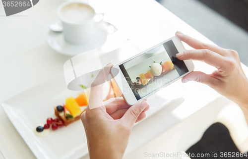 Image of close up of woman picturing food by smartphone