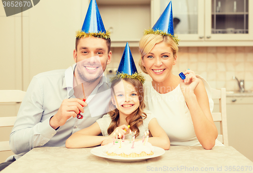 Image of smiling family in blue hats blowing favor horns