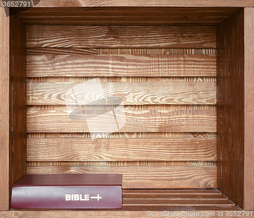 Image of Bible in old wooden shelf