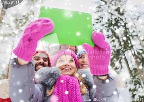 Image of smiling friends with tablet pc in winter forest