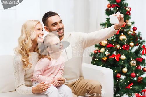 Image of family taking selfie with smartphone at christmas