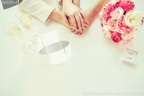 Image of close up of lesbian couple hands and wedding rings