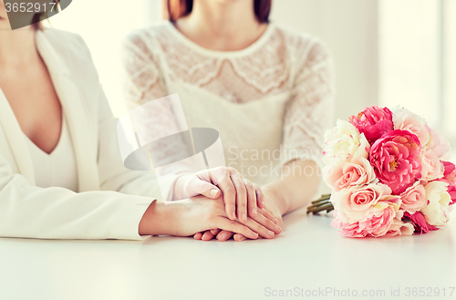 Image of close up of happy lesbian couple with flowers