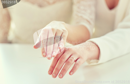 Image of close up of lesbian couple hands and wedding rings