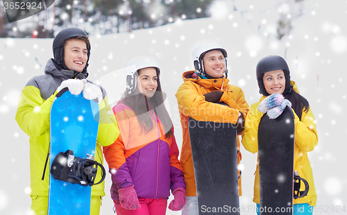 Image of happy friends in helmets with snowboards