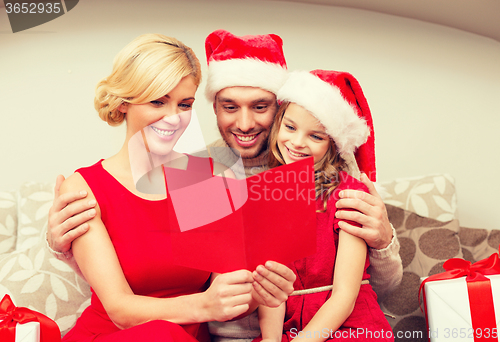 Image of smiling family reading postcard