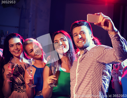 Image of friends with glasses and smartphone in club