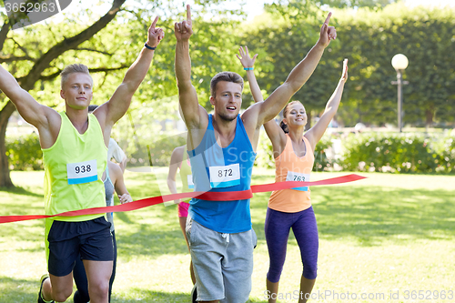 Image of happy young male runner winning on race finish