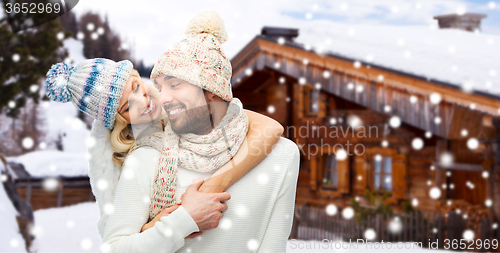 Image of smiling couple in winter clothes hugging outdoors