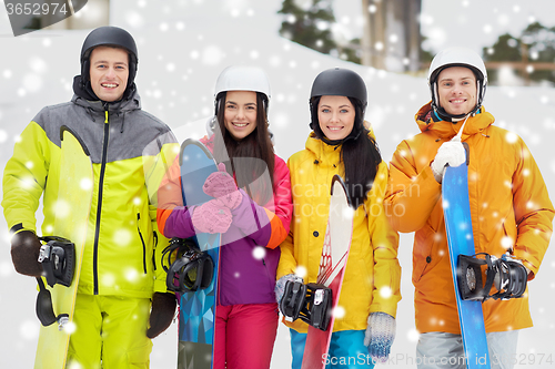 Image of happy friends in helmets with snowboards