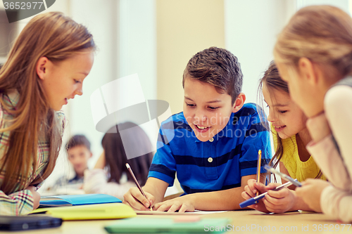 Image of group of students talking and writing at school