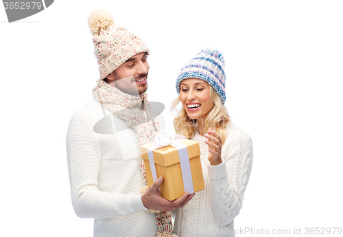 Image of smiling couple in winter clothes with gift box