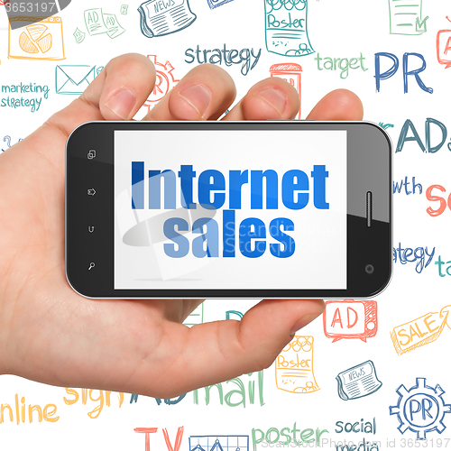 Image of Marketing concept: Hand Holding Smartphone with Internet Sales on display