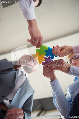 Image of business people group assembling jigsaw puzzle