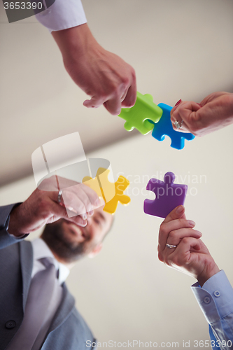 Image of business people group assembling jigsaw puzzle