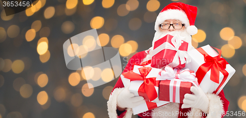 Image of man in costume of santa claus with gift boxes