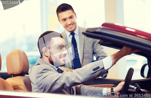 Image of happy man with car dealer in auto show or salon