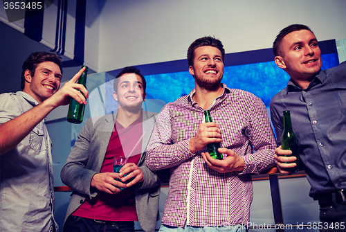 Image of group of male friends with beer in nightclub