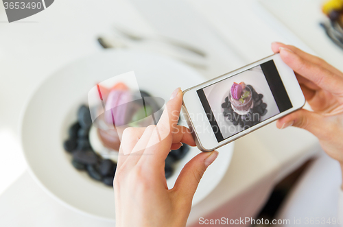 Image of close up of woman picturing food by smartphone