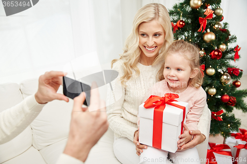 Image of family taking picture with smartphone at christmas