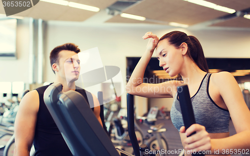 Image of woman with trainer exercising on stepper in gym