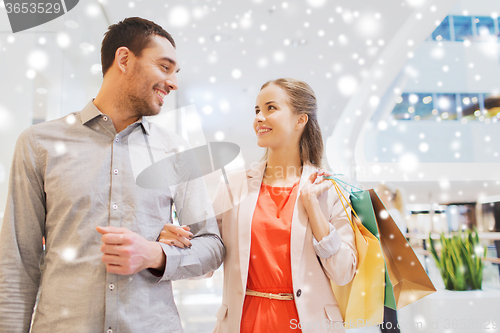 Image of happy young couple with shopping bags in mall