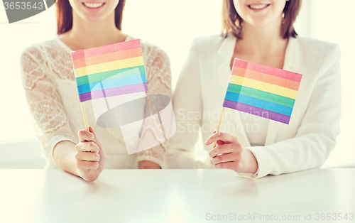 Image of close up of happy lesbian couple with rainbow flag