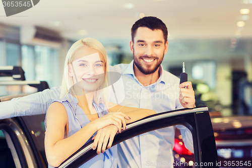 Image of happy couple buying car in auto show or salon