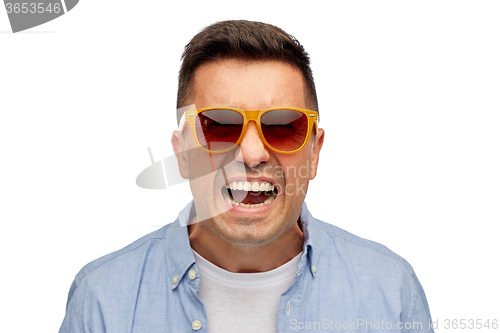 Image of face of angry man in shirt and sunglasses