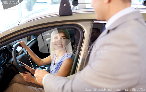 Image of happy woman with car dealer in auto show or salon