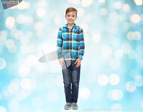 Image of happy boy in checkered shirt and jeans over lights