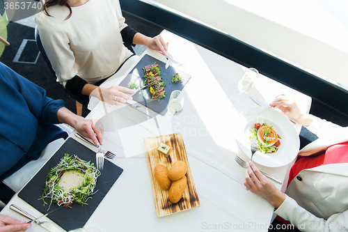 Image of close up of women eating appetizer at restaurant